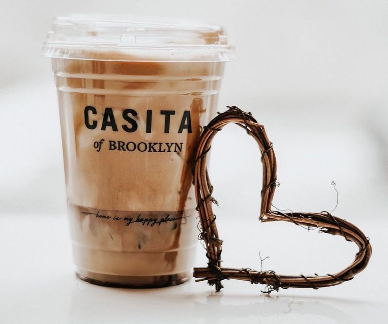 A Casita of Brooklyn iced latte beside a woven heart — home is my happy place